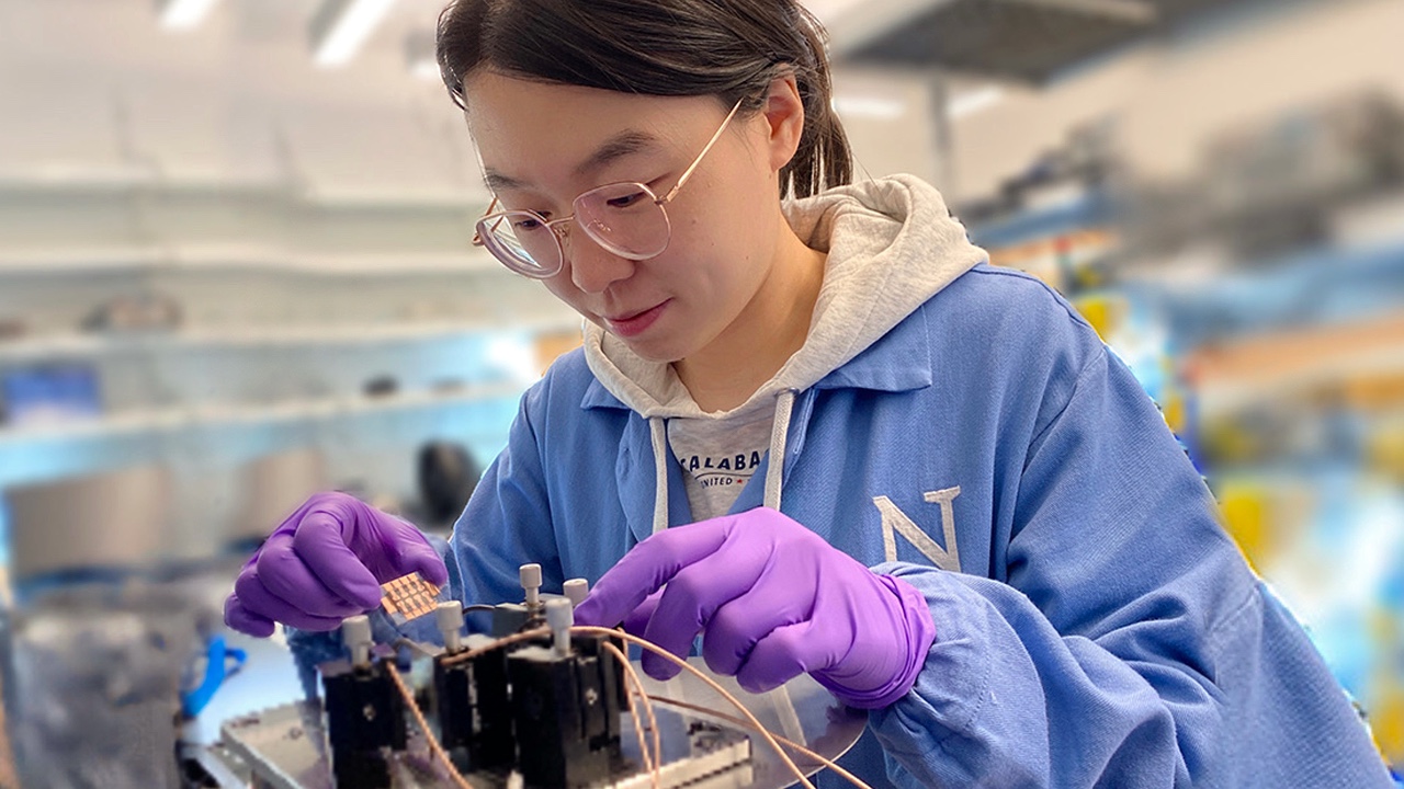 Yi Yang, the study's first author, tests a sample of the new solar cell in the lab.