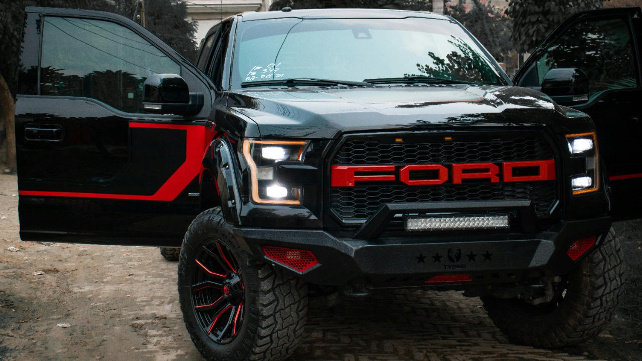Image Credit: a black and red truck parked next to another black truck — Muhammad Amaan