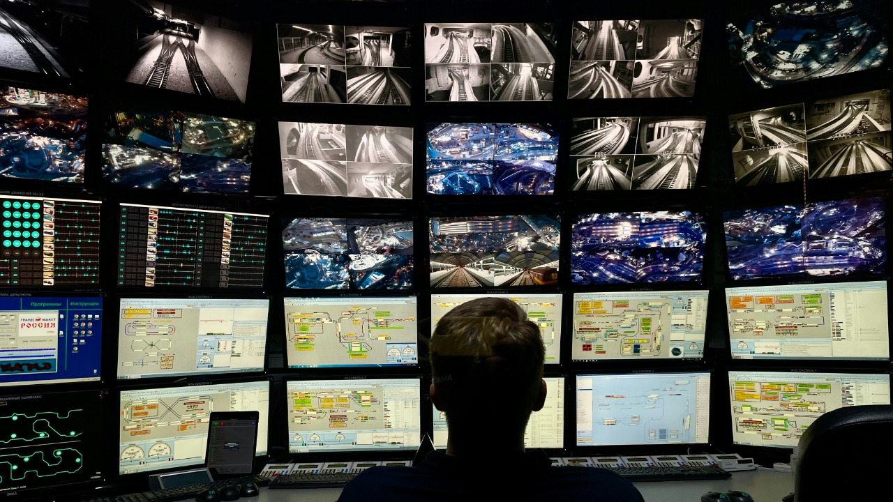 Image Credit: a man sitting in front of multiple monitors — Tasha Kostyuk