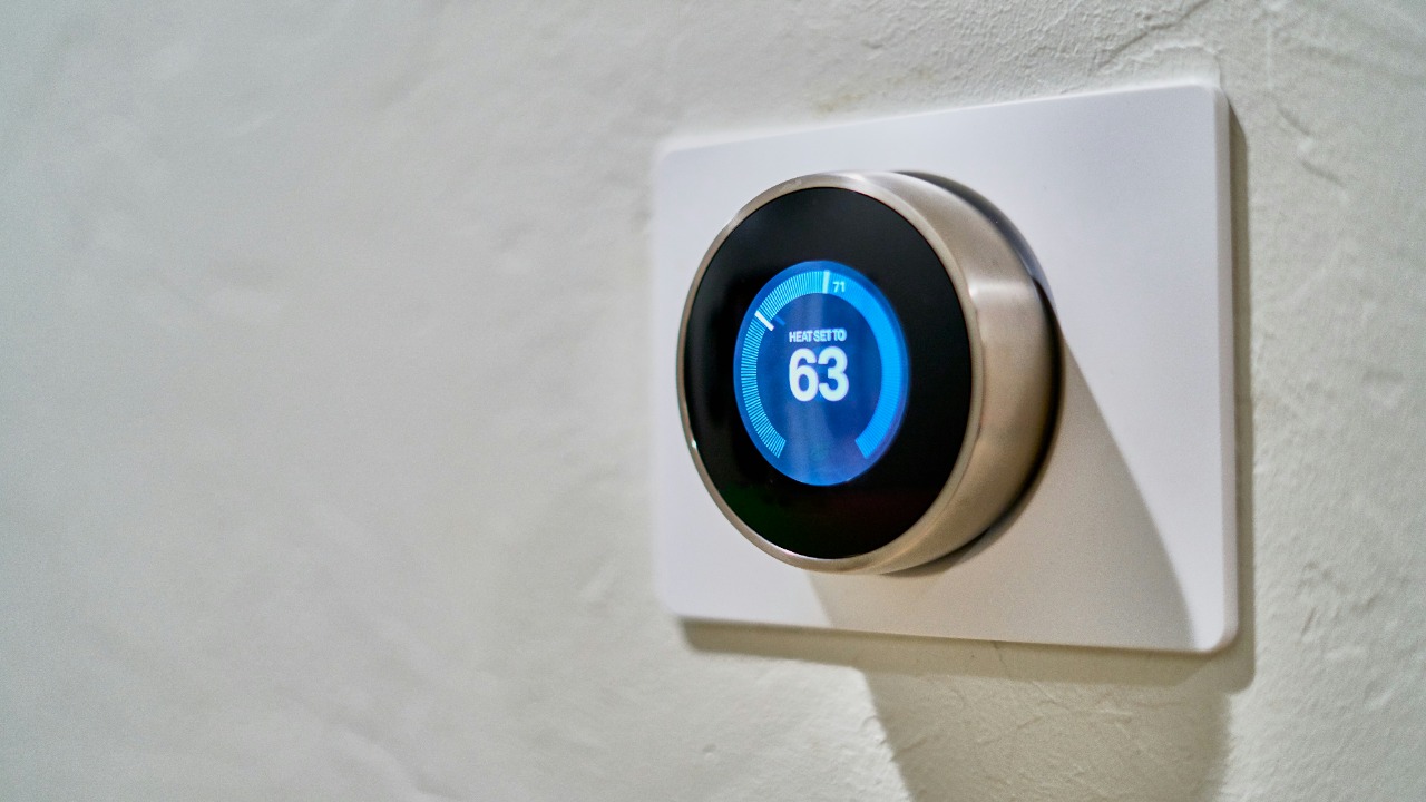 Image Credit: gray Nest thermostat displaying at 63 — Dan LeFebvre