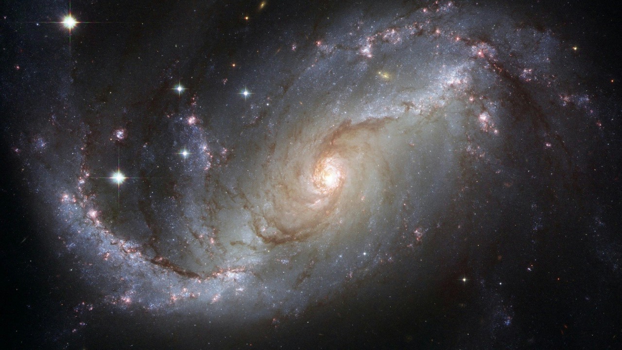 Stunning image shows spiral galaxy arm wrapping around its cosmic companion