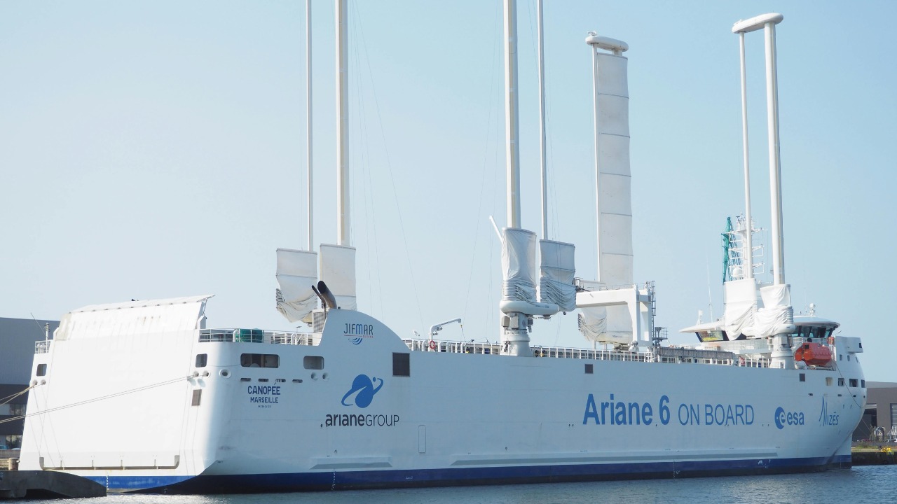 Ariane 6 cargo ship with high-tech sails docked at port during the day.