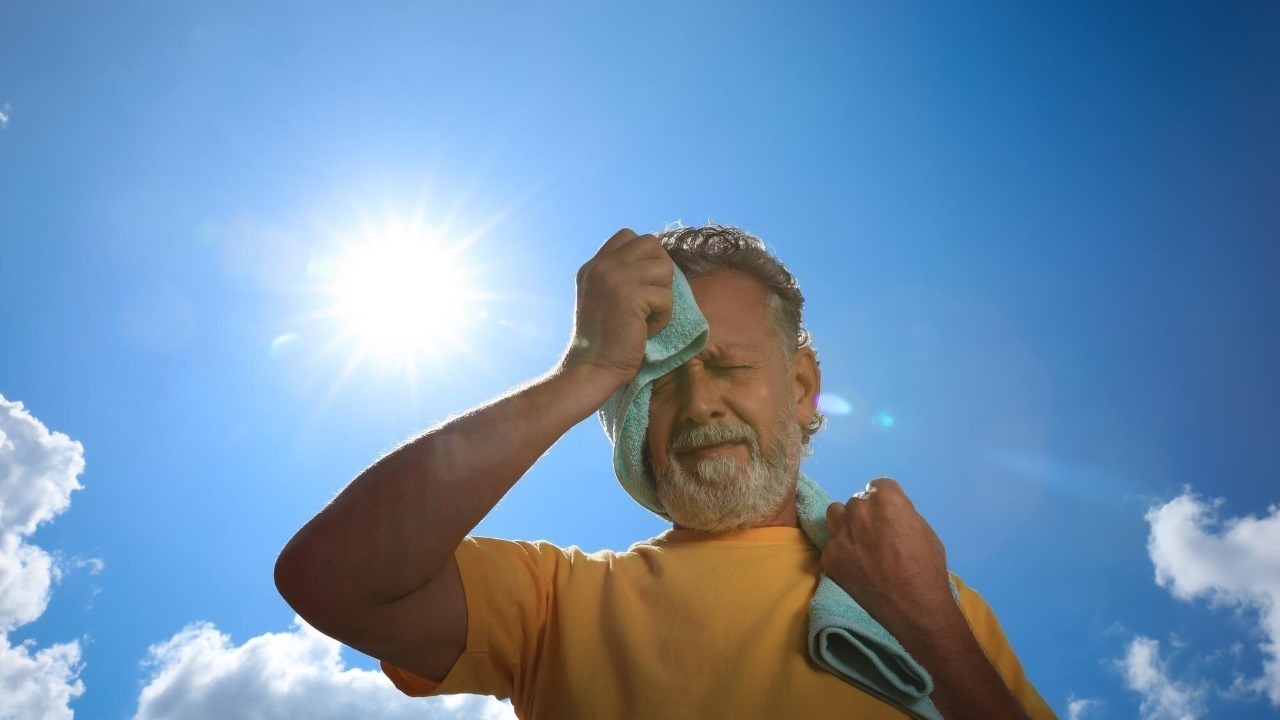Senior man with towel suffering from heat stroke outdoors low angle view Image by Freepik