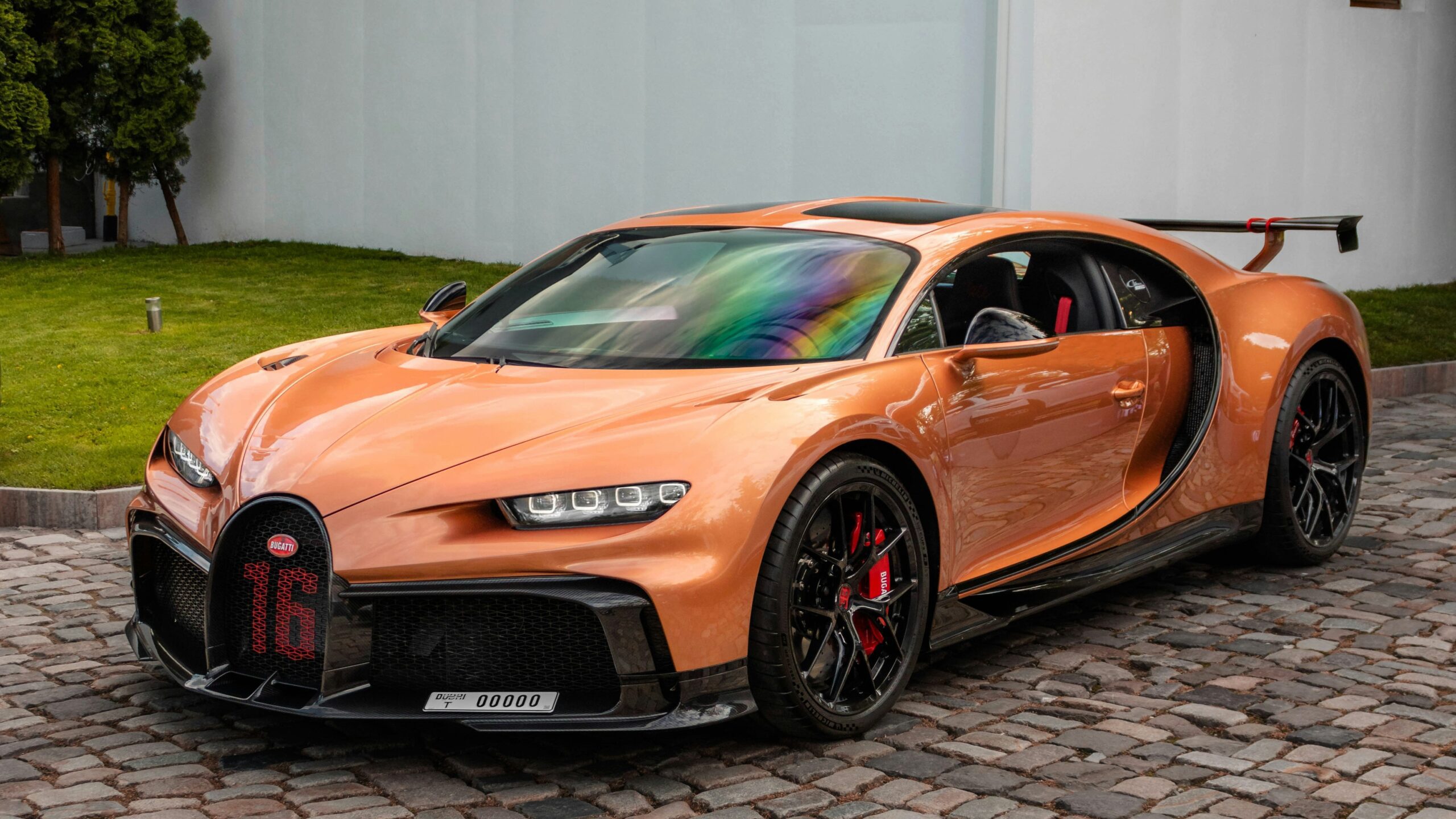 a bugatti car parked on a brick driveway