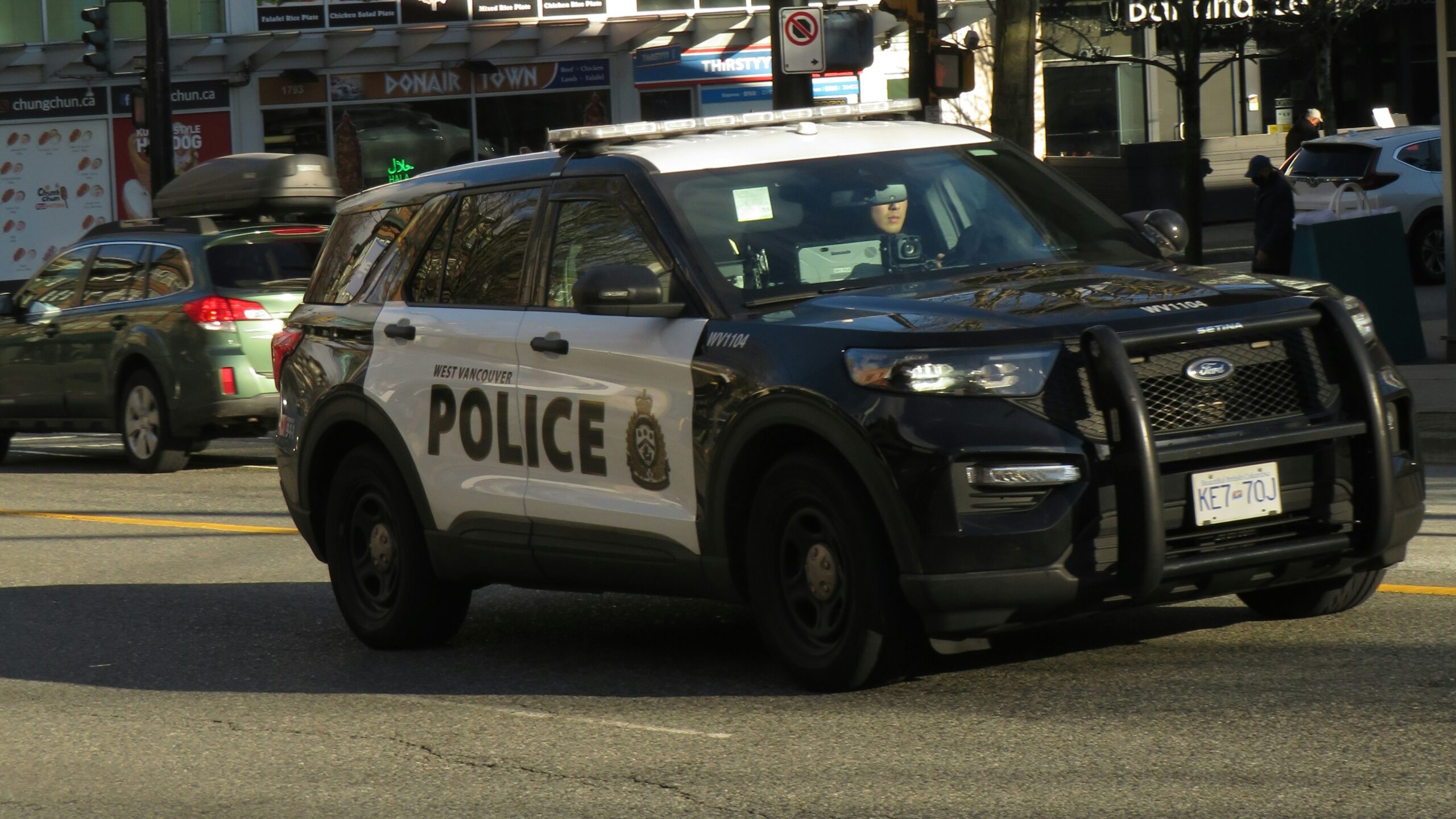 a police car driving down a street next to tall buildings
