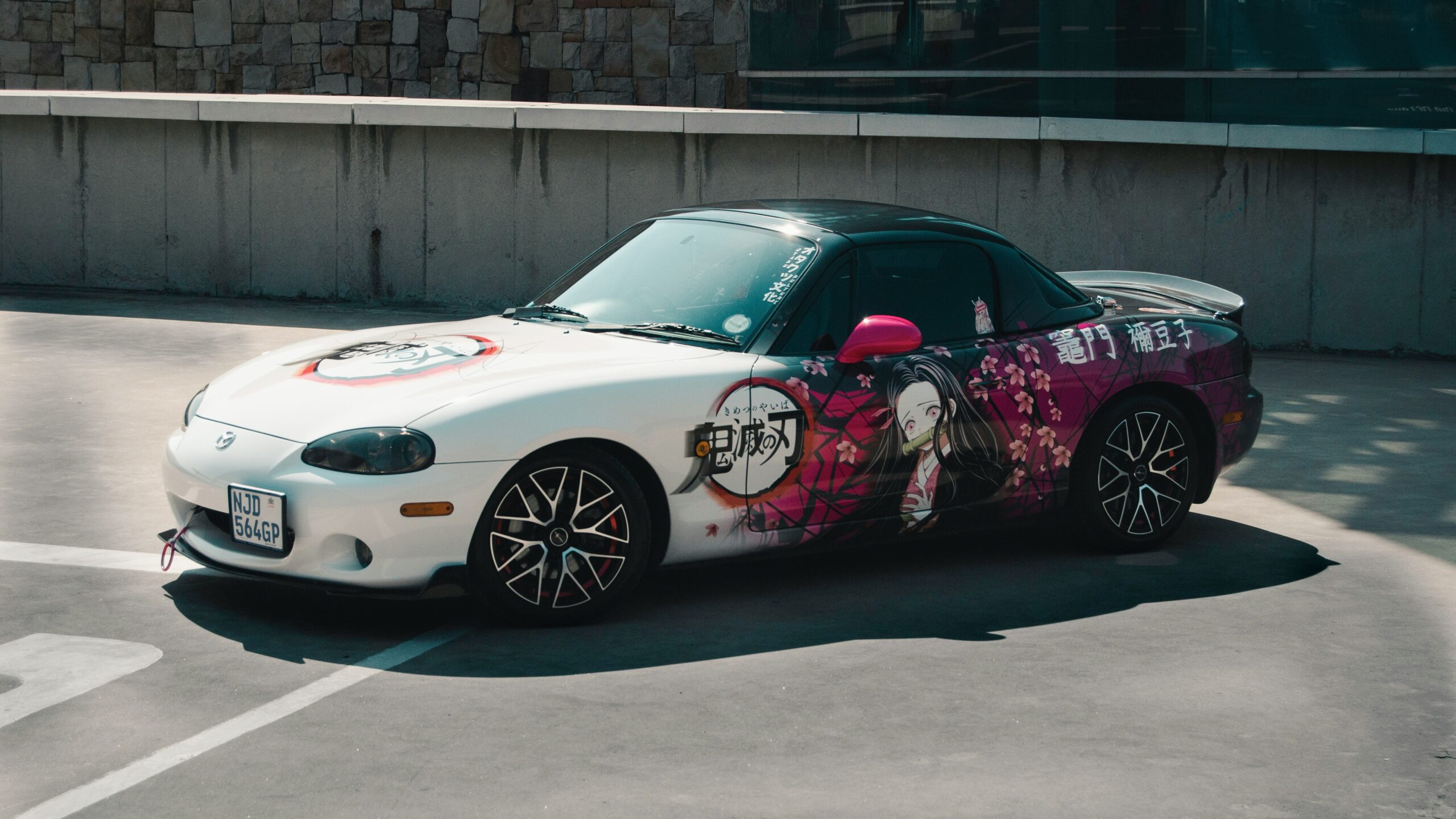 a white sports car parked in a parking lot a white sports car parked in a parking lot